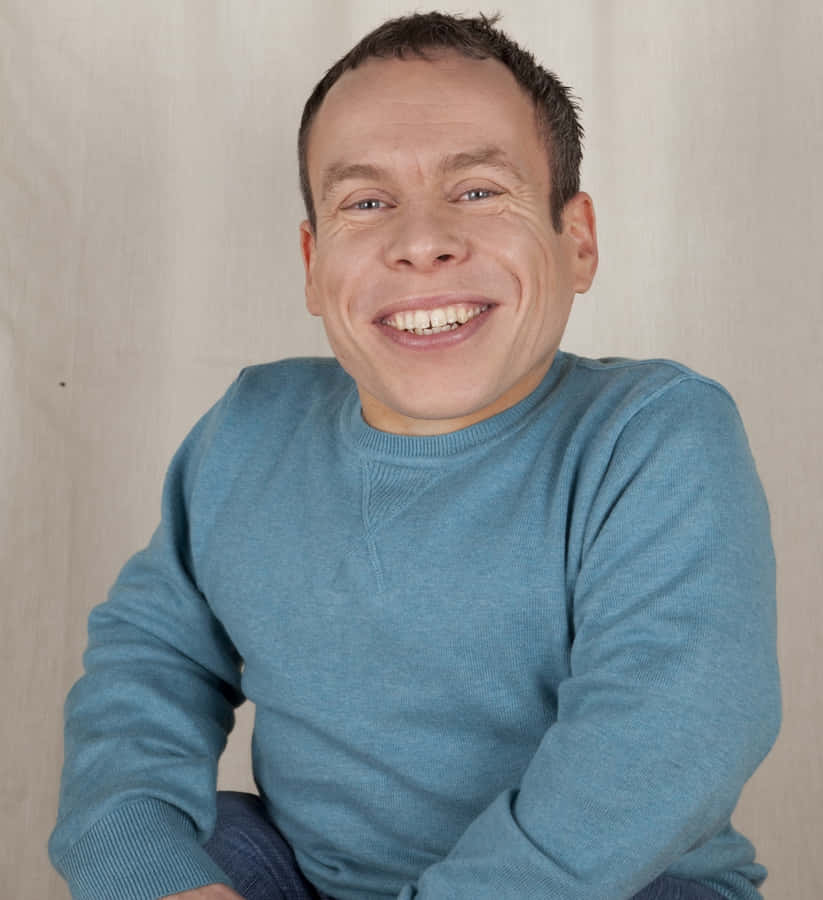 Warwick Davis Smiling In A Casual Photo Wallpaper