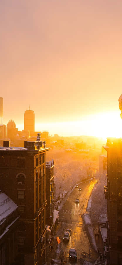 Watching The Orange Glow Of The Sunset Over The City Skyline Wallpaper