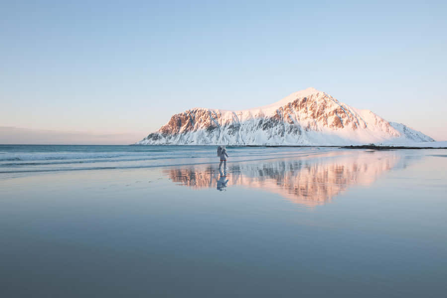 Winter Beach Scenery: Snow, Sand, And Waves Wallpaper