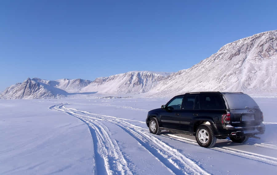 Winter Road Trip: Snowy Drive Through Scenic Mountain Terrain Wallpaper