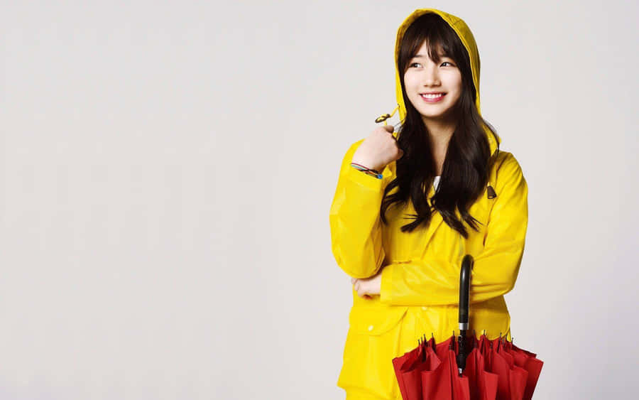 Woman In Bright Yellow Raincoat Enjoying Nature Wallpaper