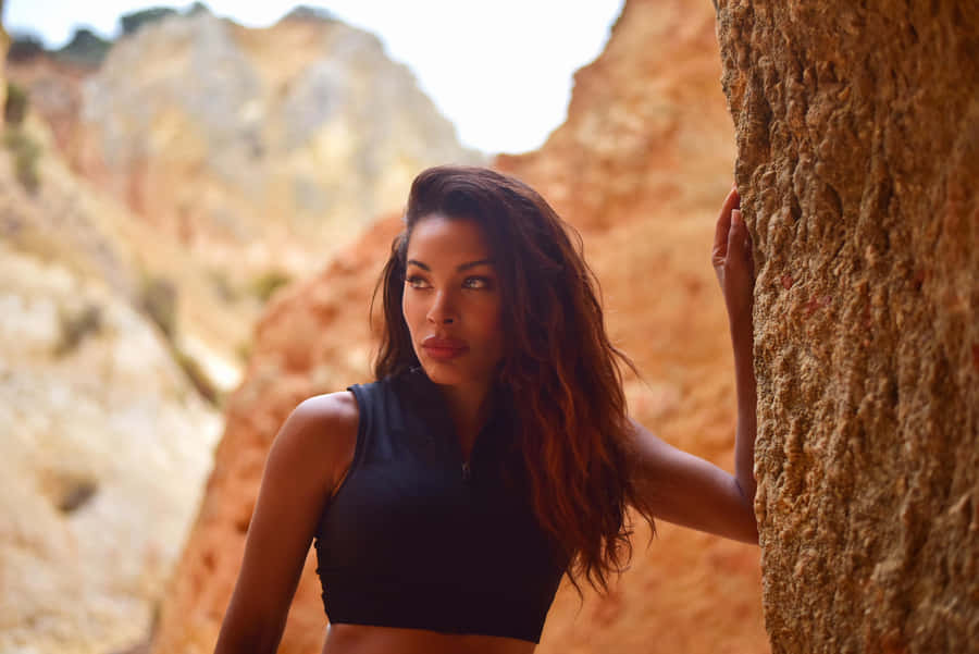 Woman Leaningon Rock Formation Wallpaper