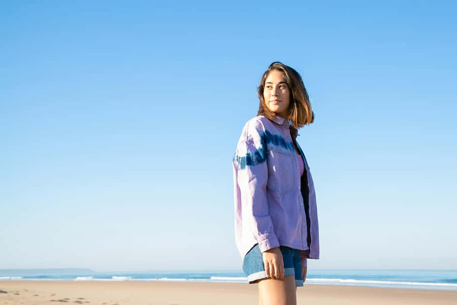 Womanin Purple Jacketat Beach Wallpaper