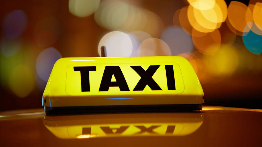 Yellow And Black Taxi Sign With Light Wallpaper