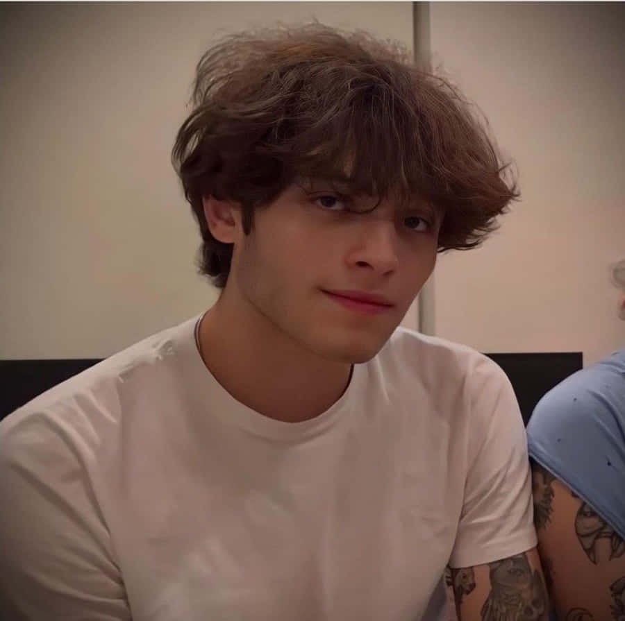 Young Manwith Curly Hairand White Shirt Wallpaper