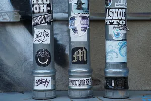 3 Gray Pipes With Stickers Wallpaper