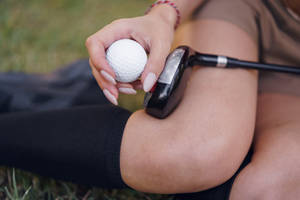 4k Golfer Holding Golf Ball And Club Wallpaper