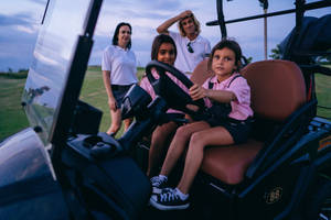 4k Kid Sitting On Golf Cart Wallpaper