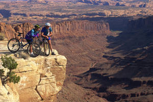 4k Mountain Bike Two Men By The Cliff Wallpaper