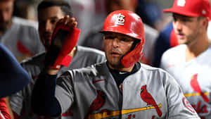 A Baseball Player Is Holding His Hand Up In The Dugout Wallpaper