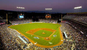 A Baseball Stadium At Night With A Crowd Of People Wallpaper