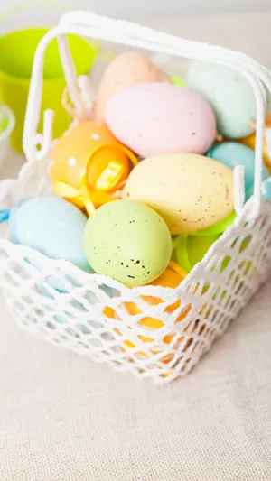 A Basket Of Colorful Easter Eggs On A Table Wallpaper