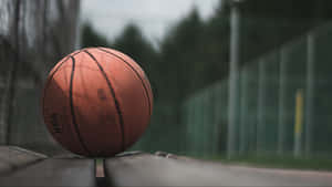 A Basketball Court Lit Up At Night Wallpaper