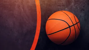 A Basketball In A Court At Dusk Wallpaper