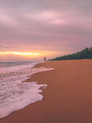 A Beach With Waves And A Sunset Wallpaper