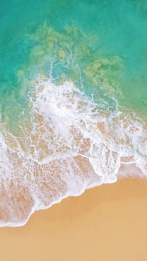 A Beach With Waves And Sand Wallpaper