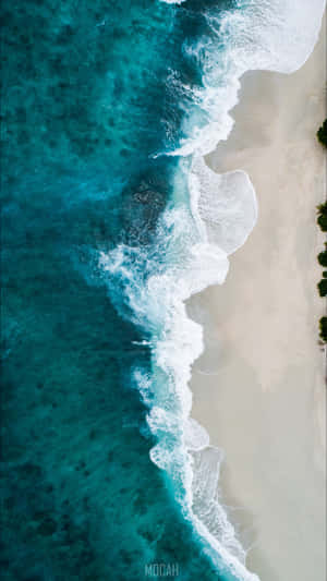 A Beach With Waves And Sand Wallpaper