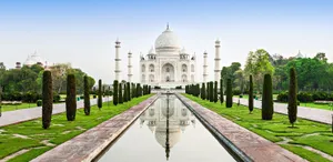 A Beachfront View Of Golden Sand And A Serene Blue Ocean Wallpaper