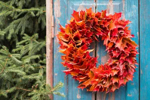 A Beautiful And Vibrant Fall Wreath On A Wooden Front Door Wallpaper