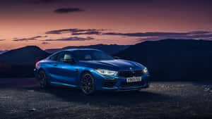 A Beautiful Blue Bmw Parked In Front Of A City Skyline Wallpaper