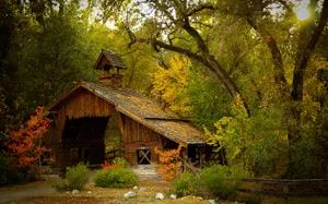 A Beautiful Rustic Barn Surrounded By Vibrant Foliage During The Fall Season. Wallpaper