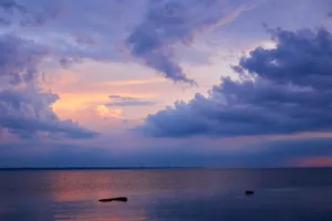 A Beautiful Sun-lit Beach With A Wide Horizon Wallpaper
