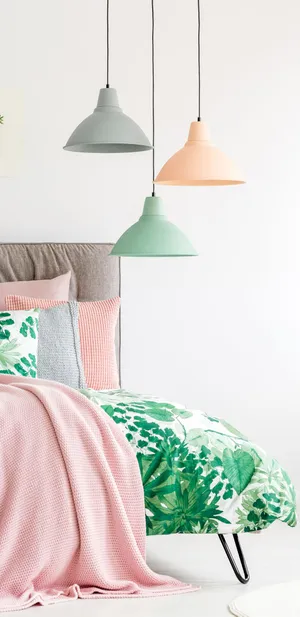 A Bedroom With Pink And Green Bedding And Lamps Wallpaper