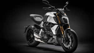 A Black And White Motorcycle Is Parked In A Dark Room Wallpaper