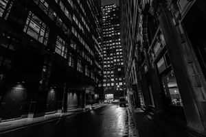A Black And White Photo Of A City Street At Night Wallpaper