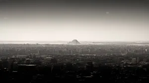 A Black And White Photo Of A City With A Mountain In The Background Wallpaper