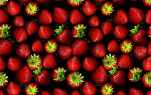 A Black Background With Many Strawberries Wallpaper