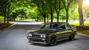 A Black Bmw E30 Parked On The Side Of The Road Wallpaper