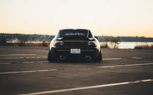 A Black Car Parked In A Parking Lot Wallpaper