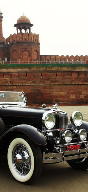 A Black Car Parked In Front Of A Building Wallpaper