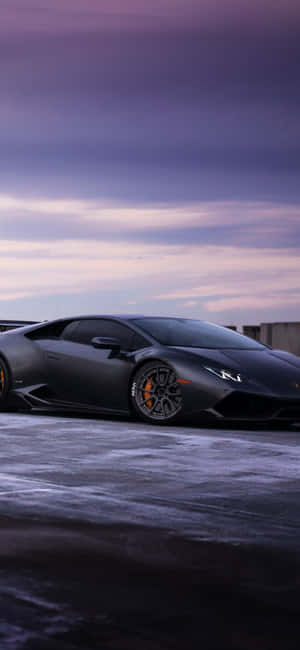 A Black Lamborghini Parked On A Snowy Road Wallpaper