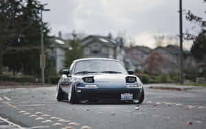 A Black Sports Car Is Parked On A Street Wallpaper