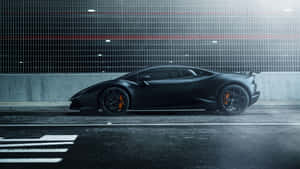 A Black Supercar Speeds Across The Road Wallpaper