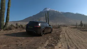 A Black Suv Is Parked On A Dirt Road Near A Mountain Wallpaper