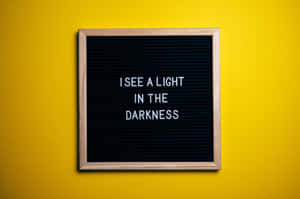 A Blackboard With The Words See A Light In The Darkness Wallpaper