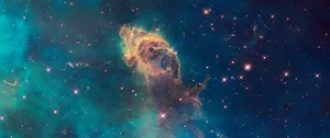 A Blue And Green Nebula With Stars In The Background Wallpaper