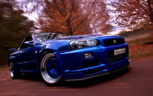 A Blue Car Driving Down A Road Wallpaper