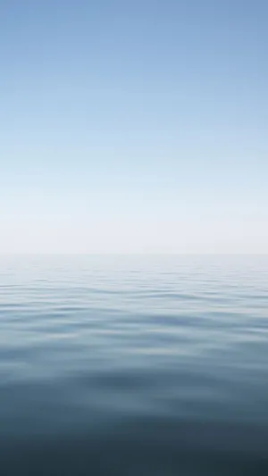 A Blue Ocean With A White Sky Wallpaper