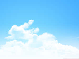 A Blue Sky With Clouds And A Plane Flying Over It Wallpaper