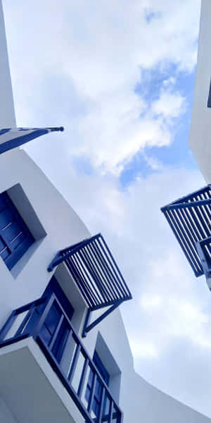 A Blue Sky With White Buildings Wallpaper