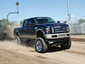 A Blue Truck Driving On Dirt Wallpaper