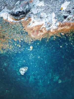 A Blue Water With A Rock In It Wallpaper