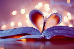 A Book With A Heart Cut Out Of It On Top Of A Table Wallpaper