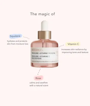 A Bottle Of Premium Rose Oil With Fresh Rose Blooms Wallpaper