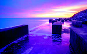 A Breathtaking Purple Sunset At The Beach Wallpaper