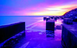 A Breathtaking Purple Sunset At The Beach Wallpaper